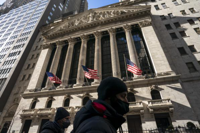A pedestrian passes the New York Stock Exchange, Monday, Jan. 24, 2022, in New York. The stock market is losing crucial support from the Federal Reserve. Omicron is causing havoc at businesses around the world. And Russia just might be preparing to invade Ukraine, creating more uncertainty and raising the prospect of even higher oil prices.